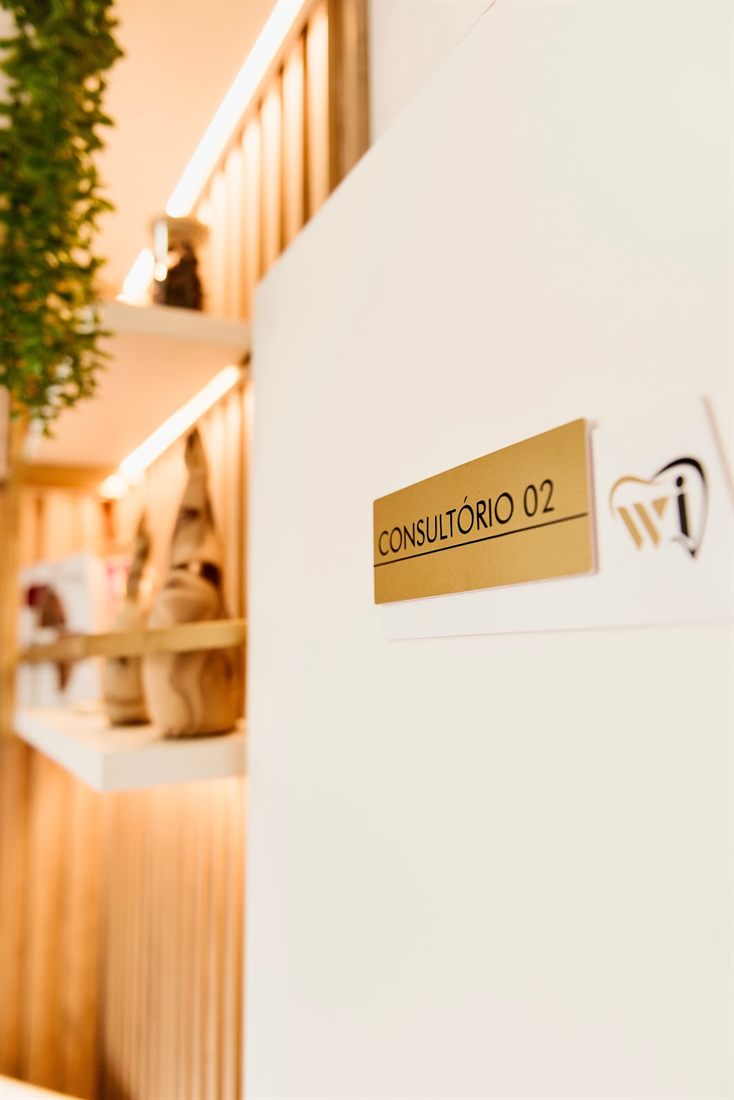 Placa dourada Consultório 02 com o logotipo da WI Odontologia